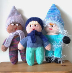 A group of three knitted mascots standing on a shelf.